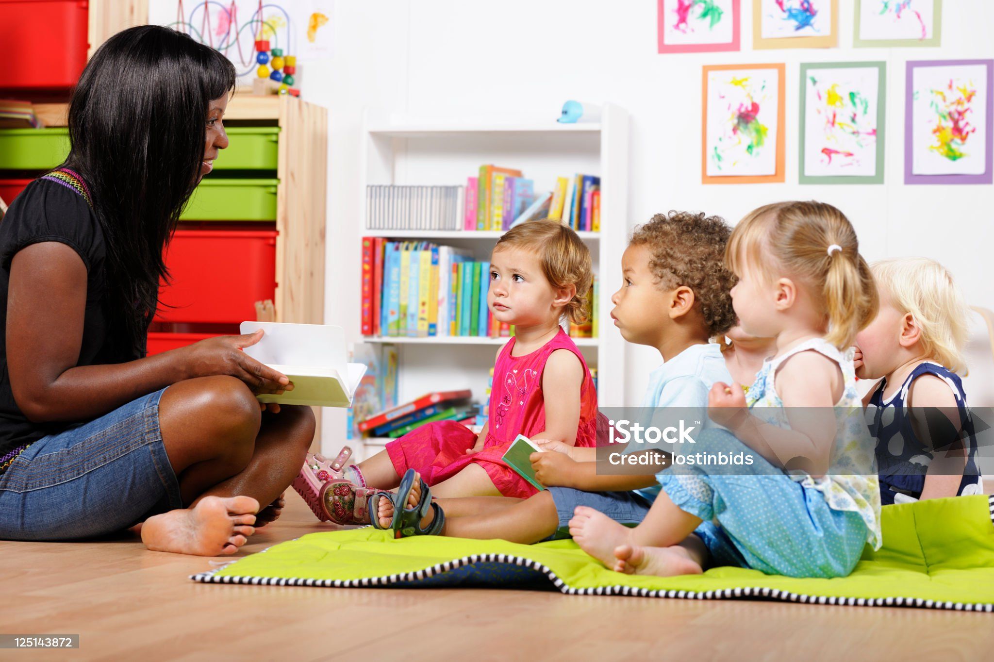 Dame lisant un livre à des enfants.